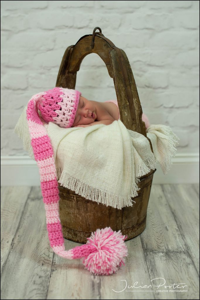 baby in a basket with long hat
